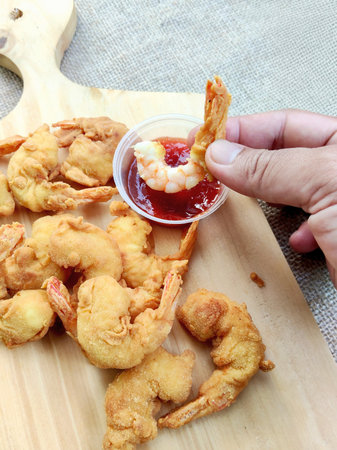 Fried shrimp with sweet and sour sauce on the wood background.の写真素材