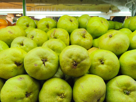 Large Pile of Fresh Green Pears Stacked for Sale at the Local Produce Marketの写真素材