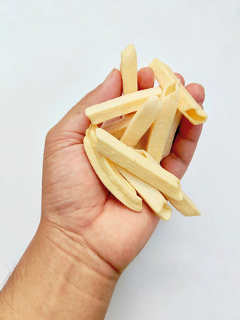 Pile of french fries in hand isolated on a white background.の写真素材