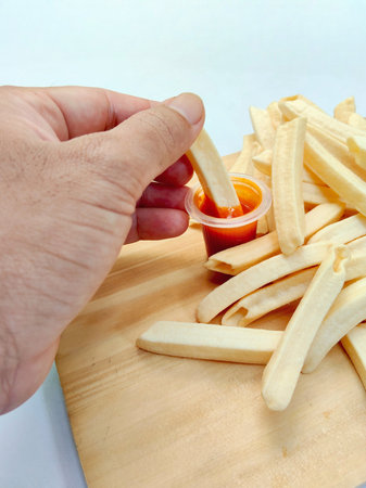 French fries and ketchup on a cutting board. Selective focus.の写真素材