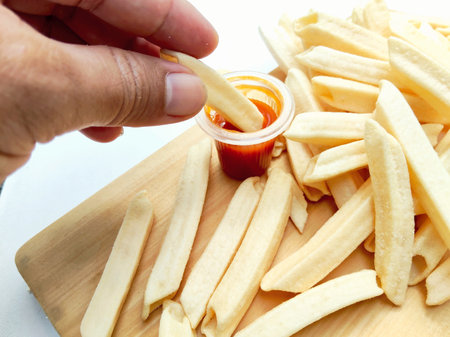 French fries with ketchup on a wooden board. Selective focus.