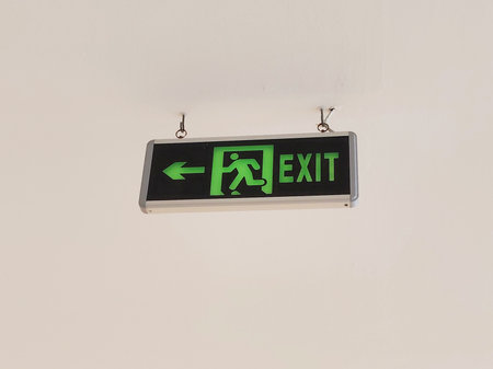 Emergency exit sign on white wall, emergency exit sign in modern buildingの写真素材