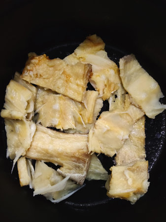 Slices of fried cabbage on a black plate, top view