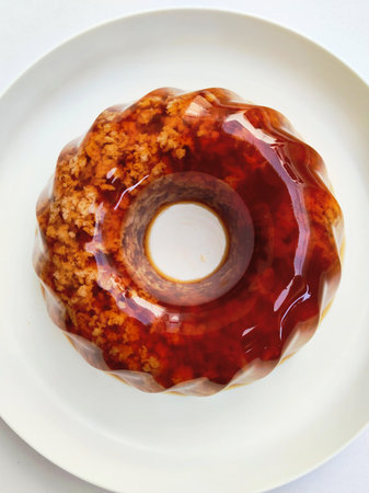 Donut with red syrup on a white plate. White background.の写真素材