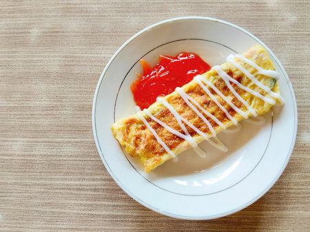 Omelet with tomato sauce on the white plateの写真素材