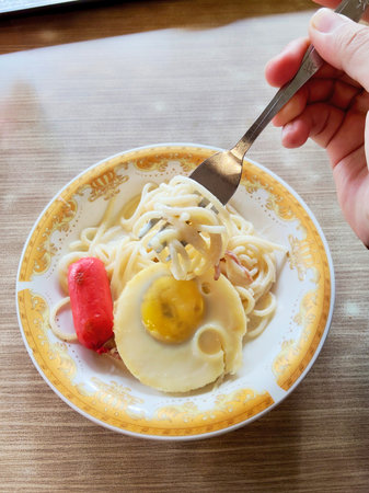 Spaghetti Carbonara with egg in white plate on wooden tableの写真素材