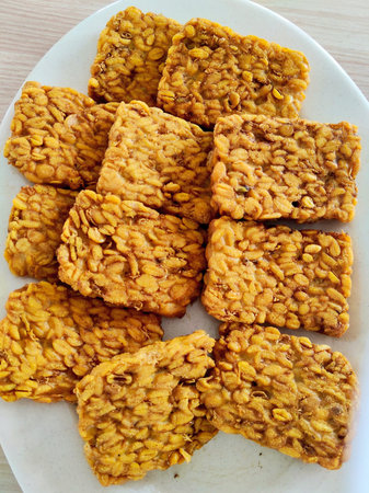 Crispy peanut butter cookies on a white plate on a wooden table
