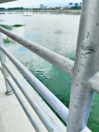 Metal railing overviewing a large calm lake