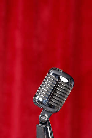 Silver microphone in front of a red curtainの写真素材