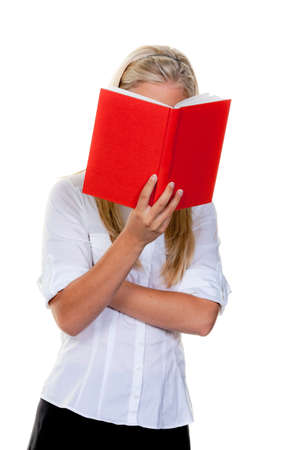 Woman holding red book in front of her face as she reads. Vertical.の写真素材