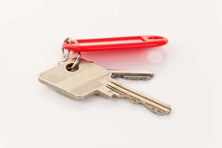 Close-up of two keys on a red key ring. Horizontal.の写真素材