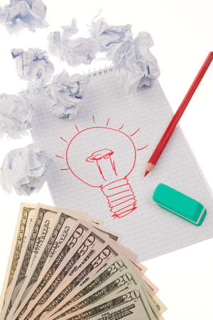 Still life with light bulb drawing, currency, pencil, eraser, and crumpled paper. Vertical.の写真素材