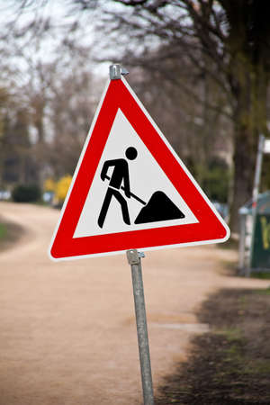 Construction road sign with construction site in the background. Vertical.の写真素材