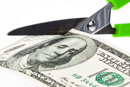 U.S. dollars bills and scissors. Duties and taxes.の写真素材