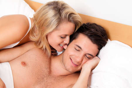 Couple has fun in bed. Laughter, joy and eroticism in the bedroomの写真素材