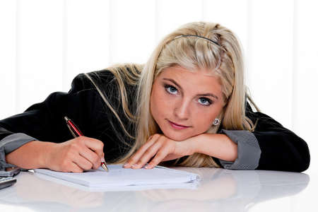 Woman with paper and pen writes a letter.