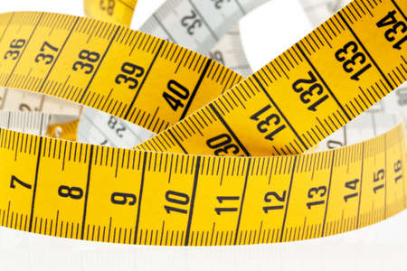 A yellow measuring tape isolated on white background.の写真素材