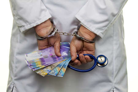 Swiss franc money and handcuffs. Crime in Medicineの写真素材