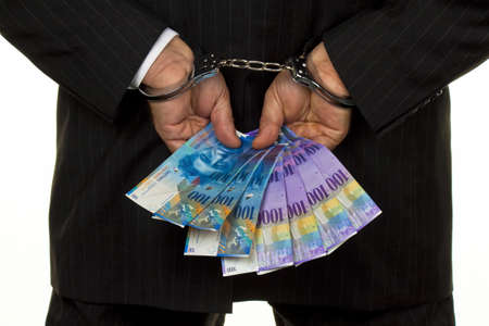 Swiss franc money and handcuffs. Crime in the economyの写真素材