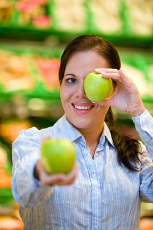 Young woman buys in the supermarket food and fruit.の写真素材