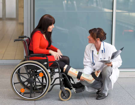 Young woman with a leg cast and wheelchair in the hospitalの写真素材