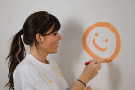 Young woman paints a picture of her first apartment.の写真素材