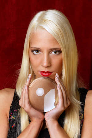 Young woman indicated the future from a crystal ball in her handsの写真素材