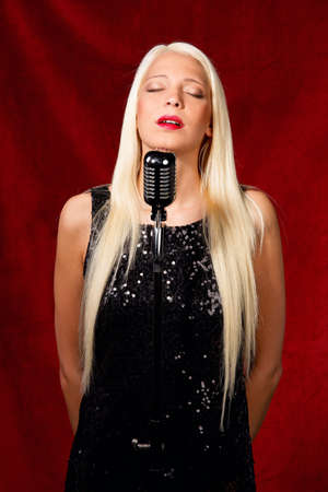 Young blond girl at a gig as a singerの写真素材