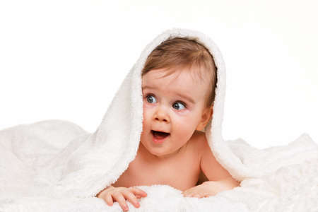 Small astonished child baby wrapped in blanketの写真素材