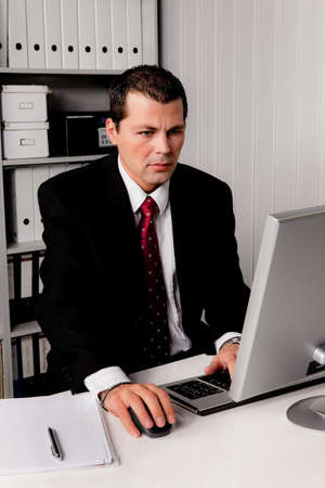 A young businessman in the office with phoneの写真素材