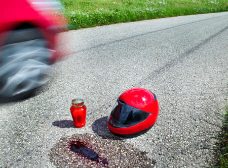 Helmet after a traffic accident on a country road. Candle and blood.の写真素材