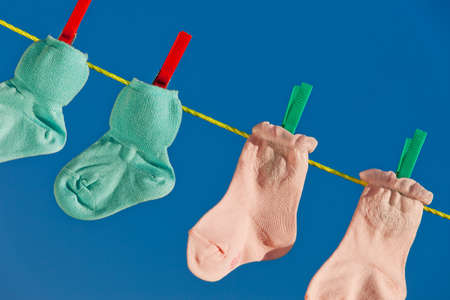 Baby socks on clothesline to dry. Blue sky.の写真素材