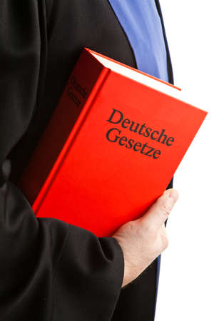 A judge with a law book in court. With Justice figure in the hand.の写真素材