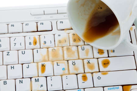 Cup of coffee spilled on a computer keyboard. Damage insurance.の写真素材