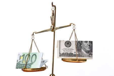 Euro notes and dollar on scales. Isolated against a white backgroundの写真素材