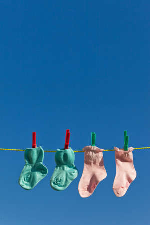 Baby socks on clothesline to dry. Blue sky.の写真素材
