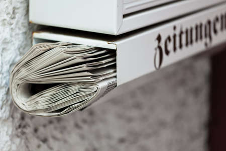 A newspaper was placed in a mailbox. Delivery of daily newspaper