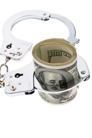 Many dollar bills with handcuffs. crime and economic crime.の写真素材