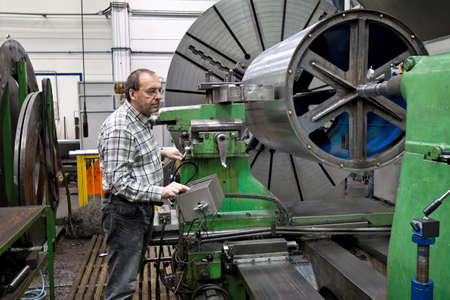 An older workers in the metal industry in CNC milling machine.の写真素材