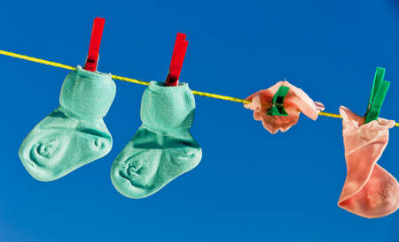 Baby socks on clothesline to dry. Blue sky.の写真素材