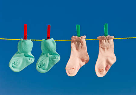 Baby socks on clothesline to dry. Blue sky.の写真素材