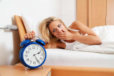Clock with sleep at night. Woman can not sleep.の写真素材
