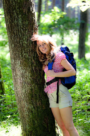 Woman in nature while hiking. Based on a treeの写真素材