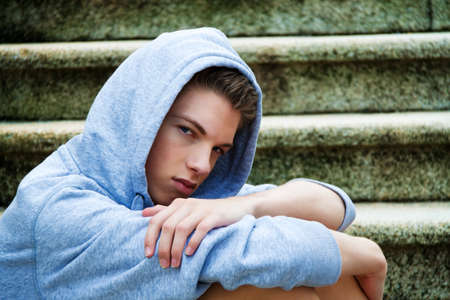 A cool-looking young man in front of graffitiの写真素材