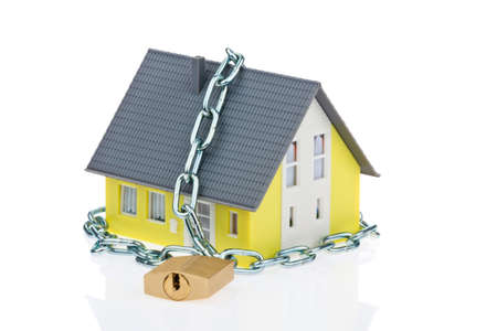A detached house with a chain and lock shut off. Alarm and security.の写真素材