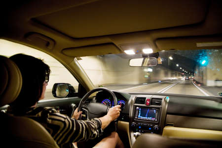 A woman drives her car into a tunnel