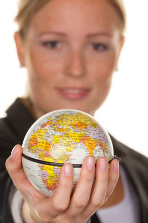 A young woman holding a globe in his hand. Symbolic photo for travel and tourism environmentの写真素材