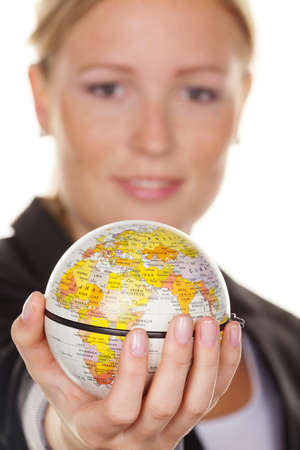 A young woman holding a globe in his hand. Symbolic photo for travel and tourism environmentの写真素材