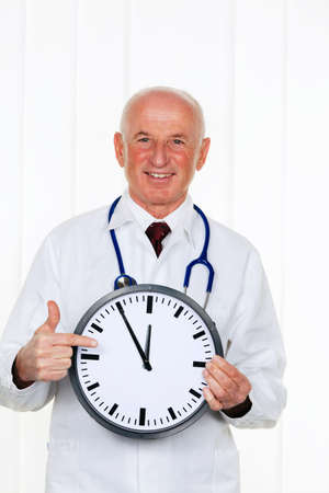 a doctor holding a clock. on the ziffernbaltt it is 11:55の写真素材