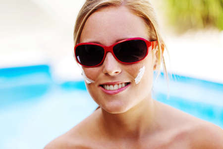 young woman with sunglasses in the summer and sun creamの写真素材